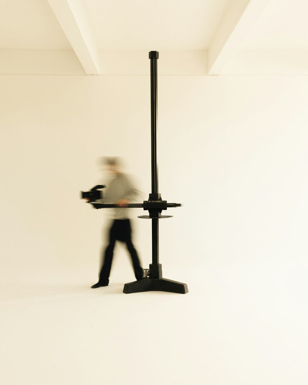 Camera operator using a robotic pedestal camera in a studio